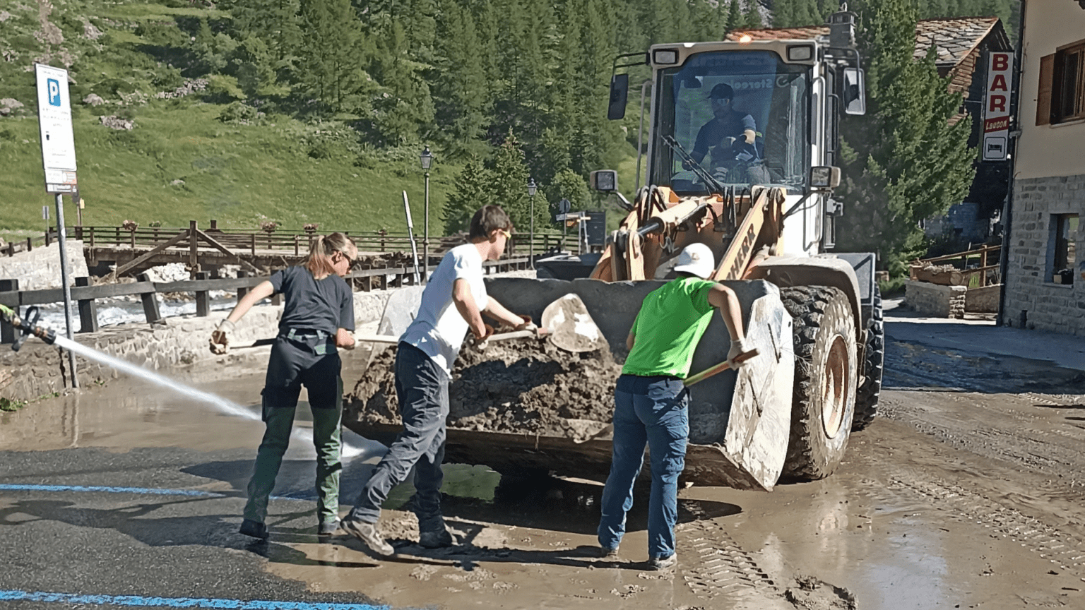 Des jeunes nettoyent les routes après les inondations, à Cogne en Vallée d'Aoste le 4 juillet 2024 / Giovani ripuliscono le strade dopo l'alluvione di Cogne, in Valle d'Aosta, il 4 luglio 2024 (c) Nos Alpes Enrico Martial